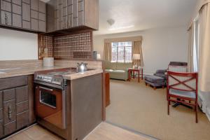 a kitchen with a stove top oven next to a living room at The Baroness Hotel in Seattle