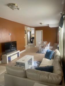 a living room with a couch and a table at Queens chateau in Laurelton