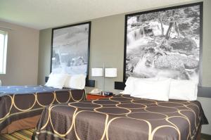 a hotel room with two beds and a large picture on the wall at Super 8 by Wyndham Clearfield in Clearfield