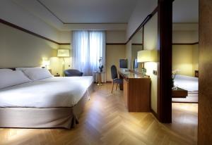 a hotel room with a bed and a desk at Exe Majestic in Naples