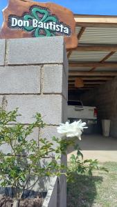 una flor blanca delante de un garaje en DON BAUTISTA en Santa Rosa de Calamuchita