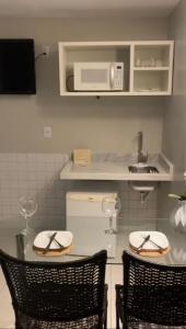 a kitchen with a table with two chairs and a microwave at HotSprings Hotel in Caldas Novas