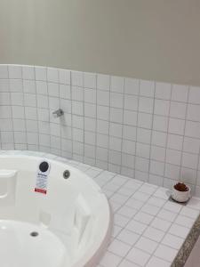 a bathroom with a white tub and a sink at HotSprings Hotel in Caldas Novas