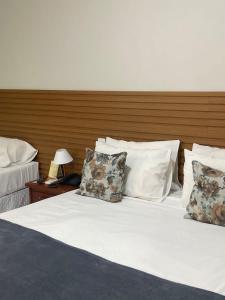 a bedroom with two beds and a wooden headboard at HotSprings Hotel in Caldas Novas