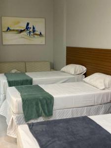 Habitación con 3 camas con mantas verdes. en HotSprings Hotel, en Caldas Novas
