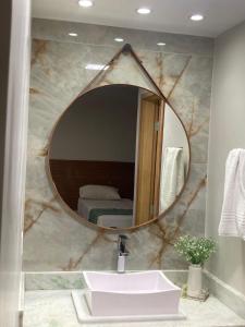 a bathroom with a large mirror over a sink at HotSprings Hotel in Caldas Novas