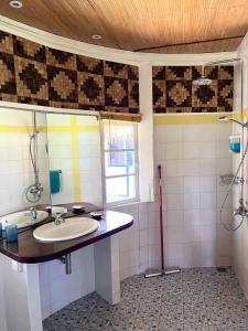 a bathroom with a sink and a shower at Linareva Moorea Beach Resort in Haapiti