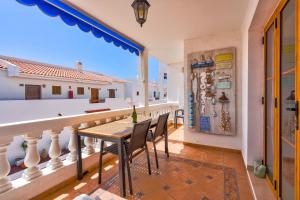 a balcony with a table and chairs and a window at Port Royal ocean view apartment in Los Cristianos in Los Cristianos