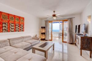 a living room with a couch and a tv at Port Royal ocean view apartment in Los Cristianos in Los Cristianos