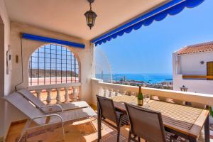 uma varanda com mesa e cadeiras e vista para o oceano em Port Royal ocean view apartment in Los Cristianos em Los Cristianos