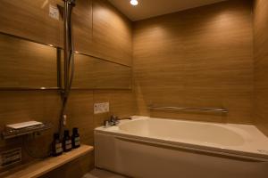 a bath tub in a bathroom with wooden walls at HOTEL ZEN-Adult Only in Hirosaki