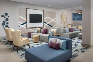 a living room with couches and a flat screen tv at Hilton Garden Inn Pensacola Downtown in Pensacola