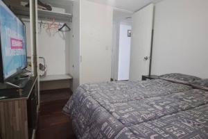 a bedroom with a bed and a flat screen tv at Departamento Completo Zona residencial la Molina in Lima