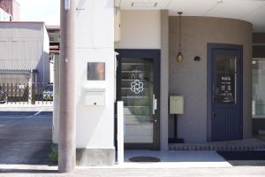 a building with a door with a sign on it at RIKKA HANASATO in Takayama