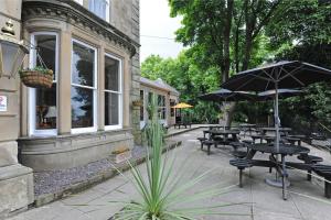 a patio with tables and umbrellas in front of a building at Brentwood Inn by Greene King Inns in Rotherham
