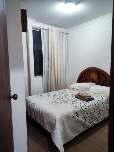 Un dormitorio con una cama con un bolso marrón. en Departamento acogedor y moderno, vista increíble., en Loja