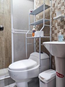 ein Badezimmer mit Toilette und Waschbecken in der Unterkunft Departamento acogedor y moderno, vista increíble. in Loja