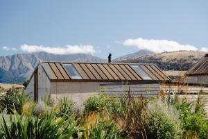 ein Haus mit einem Dach mit Bergen im Hintergrund in der Unterkunft The Earth House @ Jacks Point in Frankton