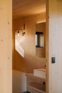 La salle de bains est pourvue d'un lavabo et d'un miroir. dans l'établissement The Earth House @ Jacks Point, à Frankton