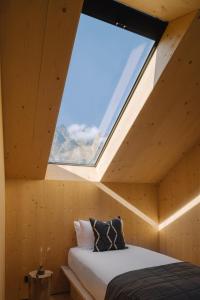 Bett in einem Holzzimmer mit Fenster in der Unterkunft The Earth House @ Jacks Point in Frankton