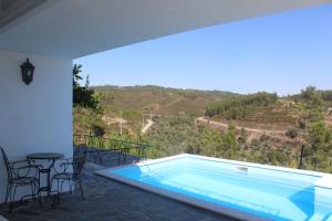 a swimming pool on a patio with a table and chairs at Casa do Cabeço in Proença-a-Nova