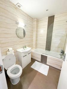 a bathroom with a toilet and a tub and a sink at Euston flat in London
