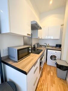 eine Küche mit einer Mikrowelle auf einer hölzernen Arbeitsplatte in der Unterkunft Euston flat in London