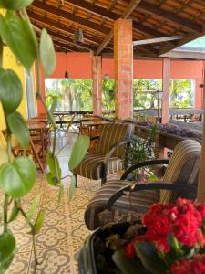 a patio with chairs and tables and flowers on the floor at Queiroz Palace Hotel in Siqueira Campos