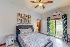 um quarto com uma cama e uma ventoinha de tecto em A1 at Blue Water Beach Villas em San Pedro