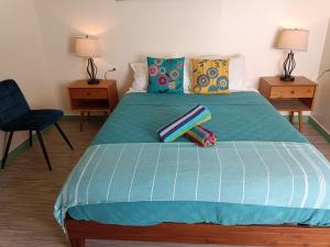 a bedroom with a bed with a blue comforter at Lazy Guesthouse in Vieques