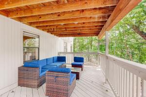 a porch with blue chairs and a wooden roof at La Bella Vida at Bella Vista in Bella Vista