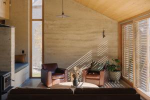 a living room with two chairs and a couch at Jacks Point - Earth House in Frankton