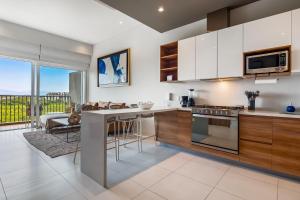a kitchen with white walls and wooden cabinets at Punto Novo 504 in Nuevo Vallarta 