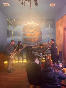 um grupo de pessoas a tocar música numa sala em Hotel Restaurante Aconcagua em La Ligua