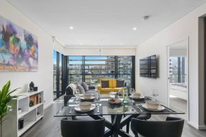 a living room with a dining table and chairs at 'Wollongong Inner-city Escape' Bright Urban Oasis in Wollongong
