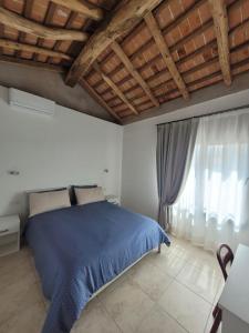 a bedroom with a blue bed and a window at Ca Marinella in Combai