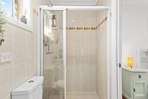 a bathroom with a shower and a toilet at Rothery Escape - A Cosy Coastal Cottage in Bellambi