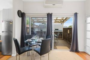 a kitchen and dining room with a table and chairs at Saltwater Escape - Live the Sand and Surf Lifestyle in Thirroul