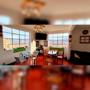 - un salon avec une table, des chaises et des fenêtres dans l'établissement Antis Cusco, à Cusco