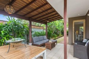 patio esterno con divano e tavolo di Thalassa Escape - Coastal Chic with Balinese Patio a Bellambi