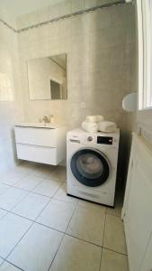 a bathroom with a washing machine and a sink at Appart hyper-centre, à 5 min à pieds de la gare in Longwy