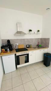 a kitchen with white cabinets and a stove top oven at Appart hyper-centre, à 5 min à pieds de la gare in Longwy