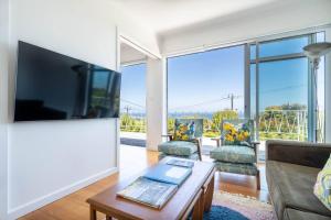 a living room with a large flat screen tv at Couples Corner - A Stylish Bay View Retreat in McCrae