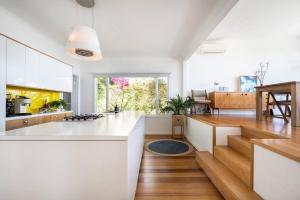 a kitchen with white cabinets and a counter top at Couples Corner - A Stylish Bay View Retreat in McCrae