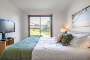 een slaapkamer met een groot bed en een groot raam bij Solander's Retro Residence - By the Beach Group Stay in Dromana