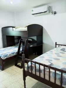 a bedroom with two bunk beds and a desk at Departamento frente al mar in Playas