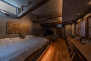 ein Schlafzimmer mit einem großen weißen Bett und einem Fernseher in der Unterkunft 媛邸【ＥＮＴＥＩ】 in Matsuyama