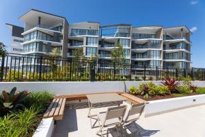 a balcony with a table and chairs in front of a building at Solaris 410 in Forster