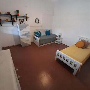 カピージャ・デル・モンテにあるOMA- Casa Temporariaのベッド2台とベッド1台が備わる小さな客室です。