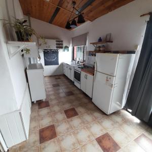 a kitchen with white appliances and a tile floor at OMA- Casa Temporaria in Capilla del Monte +9 photos